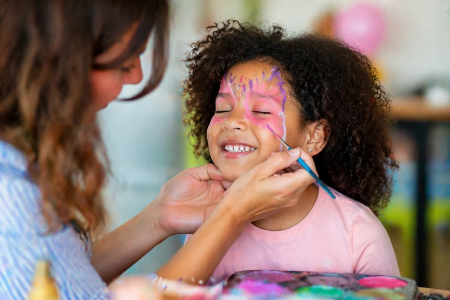 Criança a receber pinturas faciais numa festa infantil em Oeiras