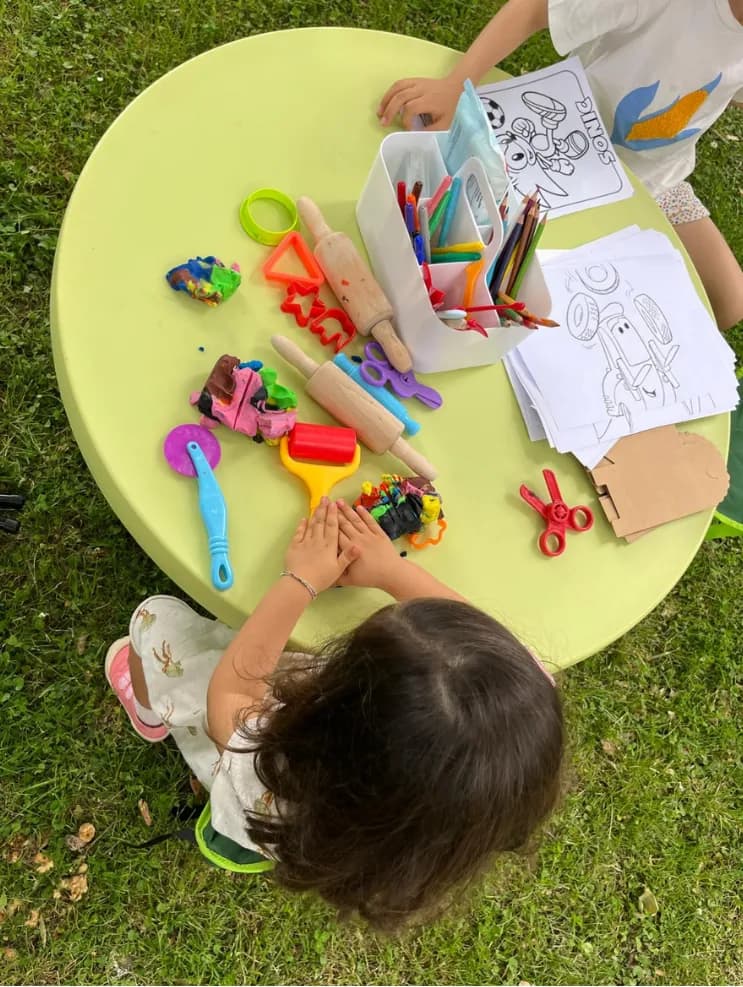 Atividade de artes plásticas numa mesa ao ar livre, festa Ludimagia