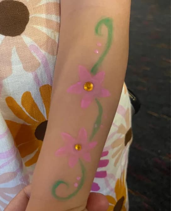 Pintura facial de flores num braço de criança, animação Ludimagia