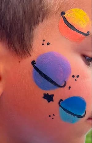 Pintura facial com tema espacial numa criança, animação Ludimagia